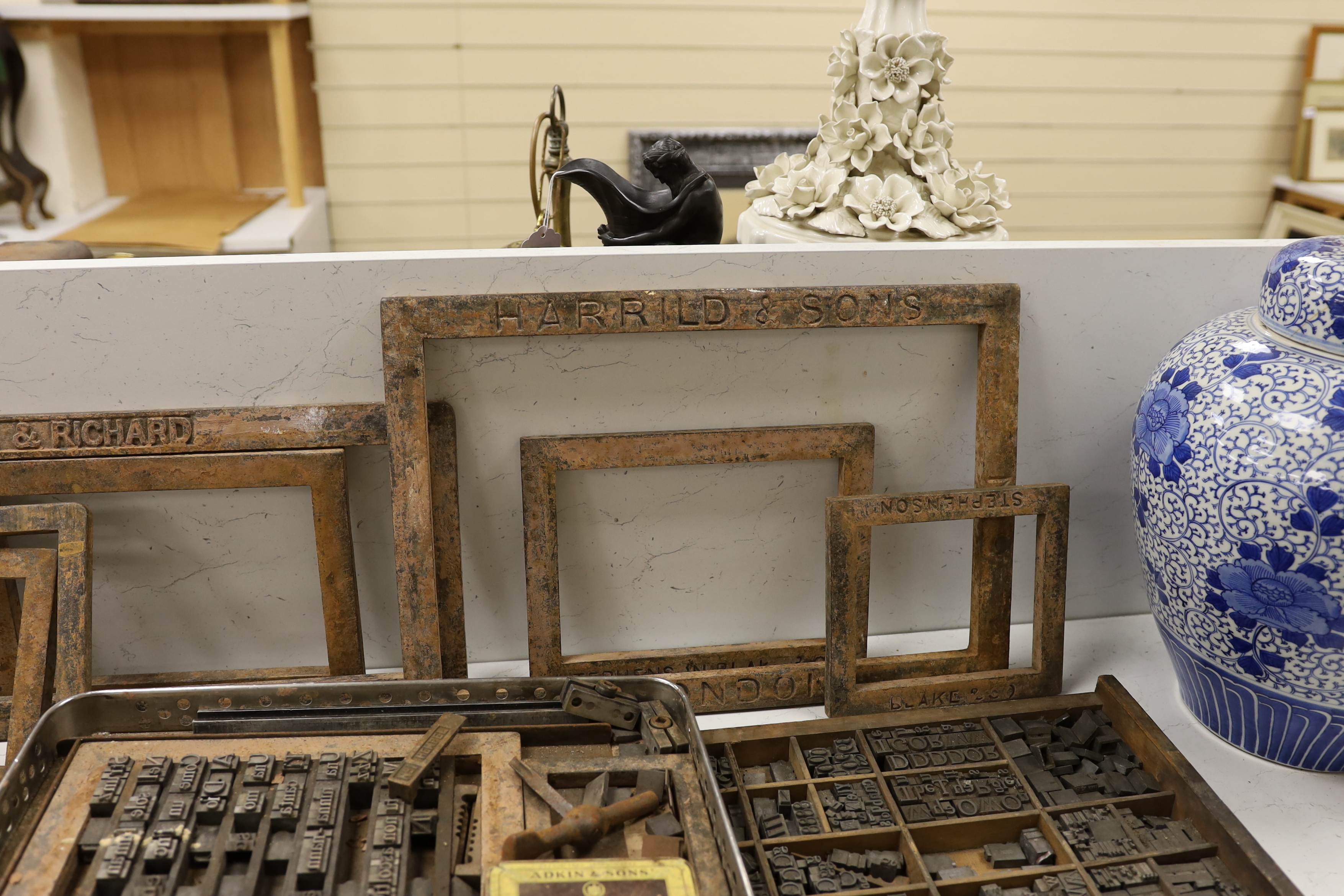 Three trays of metal printing type: chases, quoins and spacing bars